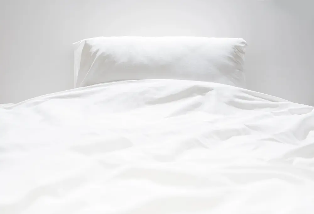 Frisch gemachtes Bett in einem hellen, sauberen Apartment